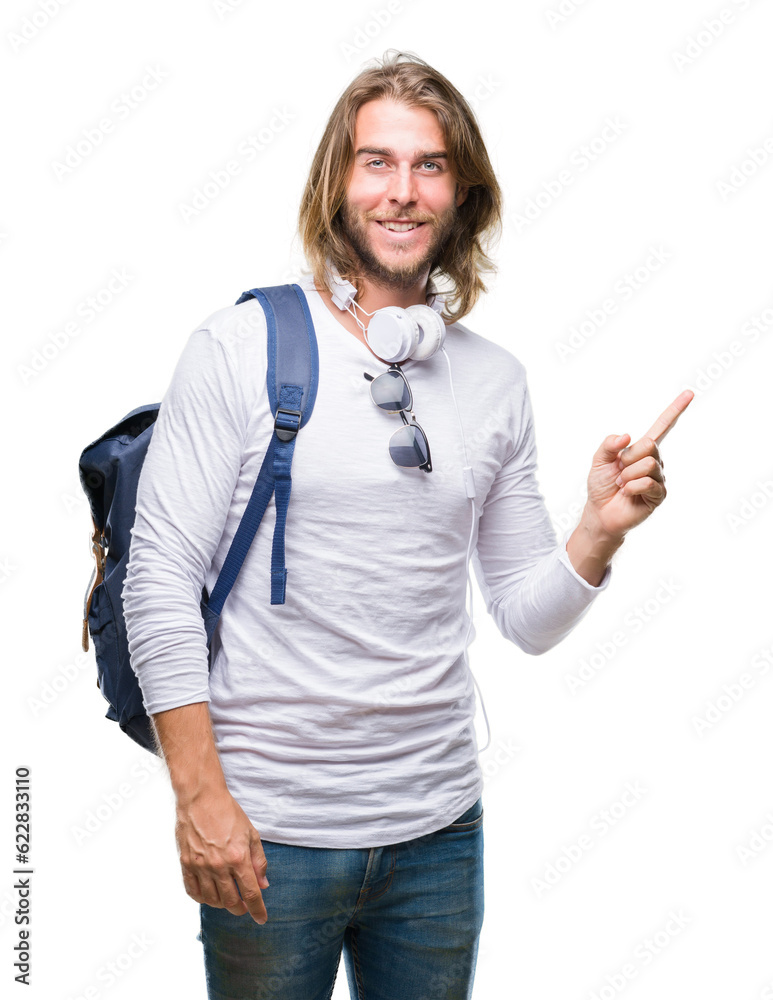 Obraz premium Young handsome tourist man with long hair wearing backpack over isolated background with a big smile on face, pointing with hand and finger to the side looking at the camera.