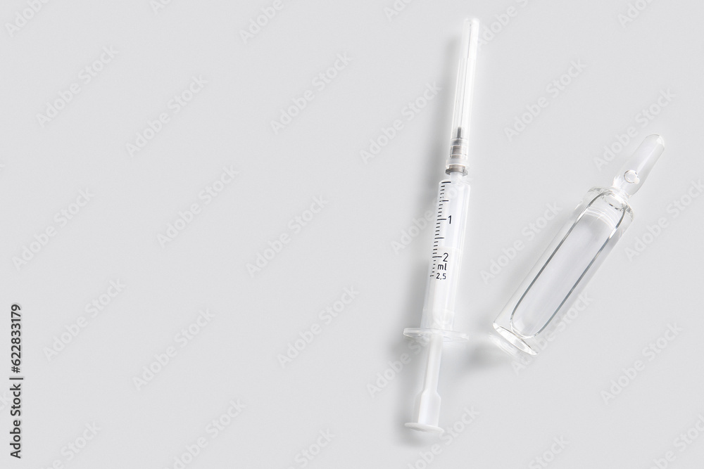 Medical ampule with syringe on light background Medical ampule with syringe on light background