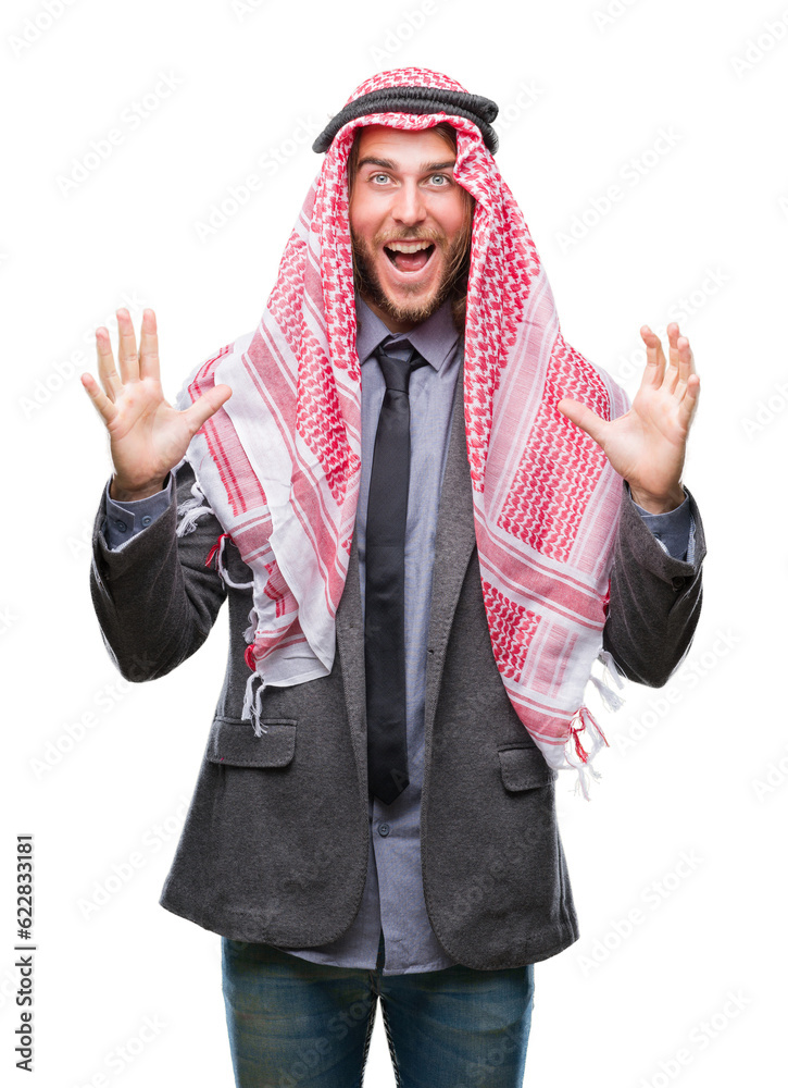Young handsome arabian man with long hair wearing keffiyeh over isolated background celebrating crazy and amazed for success with arms raised and open eyes screaming excited. Winner concept Young handsome arabian man with long hair wearing keffiyeh over isolated background celebrating crazy and amazed for success with arms raised and open eyes screaming excited. Winner concept