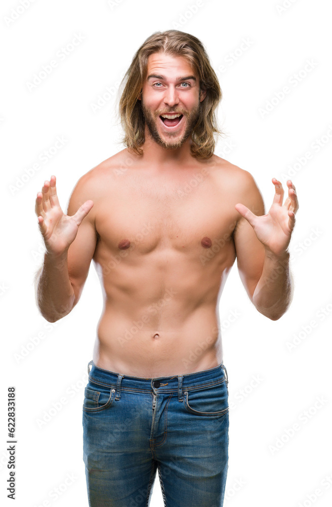Fototapeta premium Young handsome shirtless man with long hair showing sexy body over isolated background celebrating crazy and amazed for success with arms raised and open eyes screaming excited. Winner concept