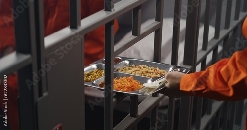 Cuadro en lienzo Elderly prisoner in orange uniform sits in prison cell