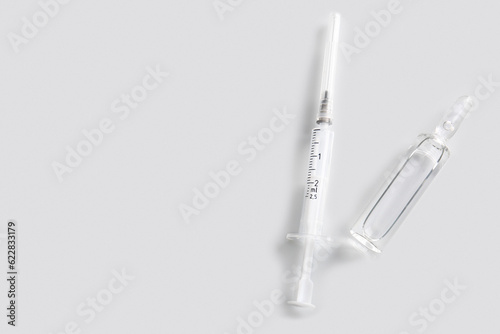 Medical ampule with syringe on light background