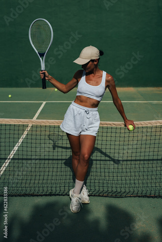 beautiful girl athlete plays tennis on the tennis court on a sunny summer day