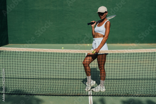 beautiful girl athlete plays tennis on the tennis court on a sunny summer day © sutulastock