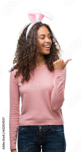 Photography Young hispanic woman wearing easter bunny ears pointing and showing with thumb u