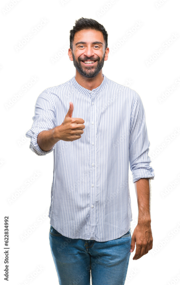 Adult hispanic man over isolated background doing happy thumbs up gesture with hand. Approving expression looking at the camera with showing success. Adult hispanic man over isolated background doing happy thumbs up gesture with hand. Approving expression looking at the camera with showing success.