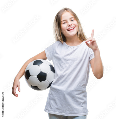 Young beautiful girl holding soccer football ball over isolated background surprised with an idea or question pointing finger with happy face, number one