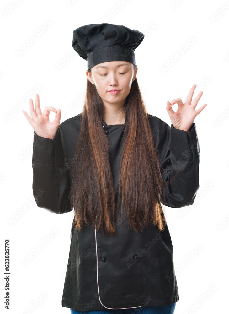Young Chinese woman over isolated background wearing chef uniform relax and smiling with eyes closed doing meditation gesture with fingers. Yoga concept. Young Chinese woman over isolated background wearing chef uniform relax and smiling with eyes closed doing meditation gesture with fingers. Yoga concept.