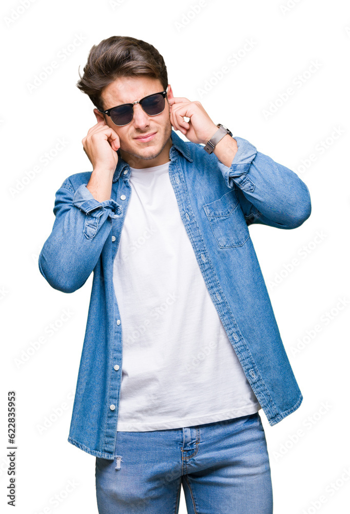 Young handsome man wearing sunglasses over isolated background covering ears with fingers with annoyed expression for the noise of loud music. Deaf concept. Young handsome man wearing sunglasses over isolated background covering ears with fingers with annoyed expression for the noise of loud music. Deaf concept.