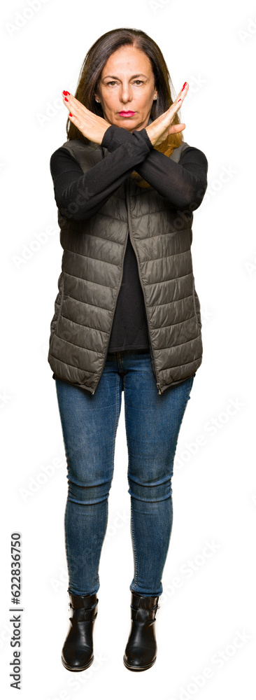 Obraz premium Beautiful middle age woman wearing winter vest Rejection expression crossing arms doing negative sign, angry face