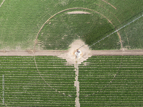 A zoom on the middle of a round agricultural field and it's irrigation system from a drone view 