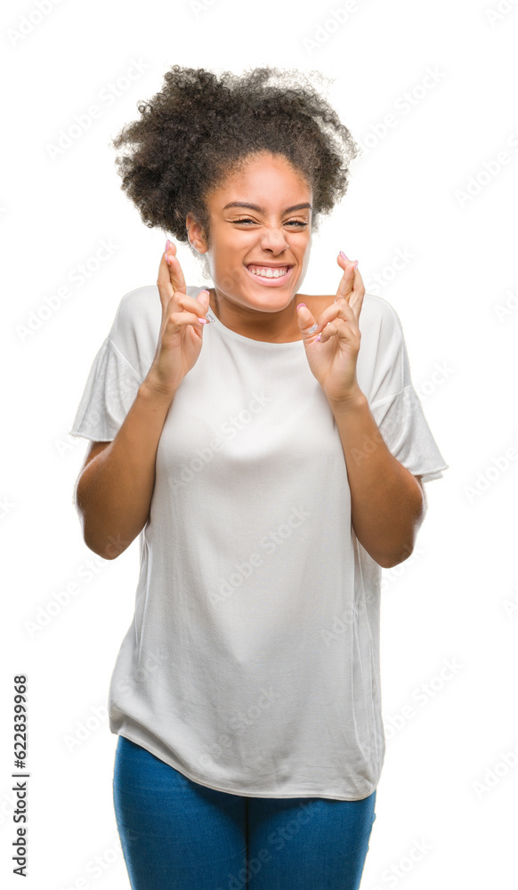 Young afro american woman over isolated background smiling crossing fingers with hope and eyes closed. Luck and superstitious concept. Young afro american woman over isolated background smiling crossing fingers with hope and eyes closed. Luck and superstitious concept.