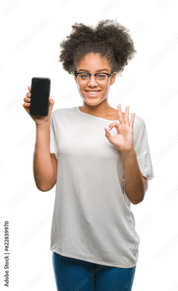Young beautiful afro american showing smartphone screen over isolated background doing ok sign with fingers, excellent symbol Young beautiful afro american showing smartphone screen over isolated background doing ok sign with fingers, excellent symbol