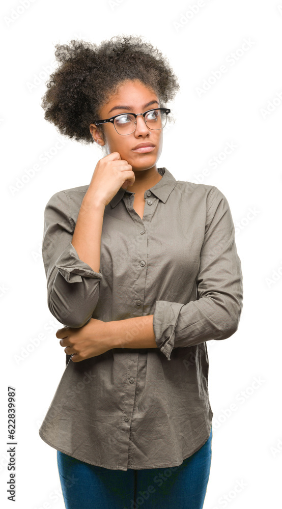 Young afro american woman wearing glasses over isolated background with hand on chin thinking about question, pensive expression. Smiling with thoughtful face. Doubt concept. Young afro american woman wearing glasses over isolated background with hand on chin thinking about question, pensive expression. Smiling with thoughtful face. Doubt concept.