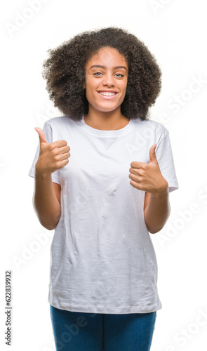 Young afro american woman over isolated background success sign doing positive gesture with hand, thumbs up smiling and happy. Looking at the camera with cheerful expression, winner gesture.