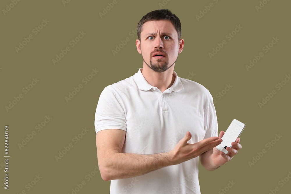 Shocked man with smartphone on color background Shocked man with smartphone on color background