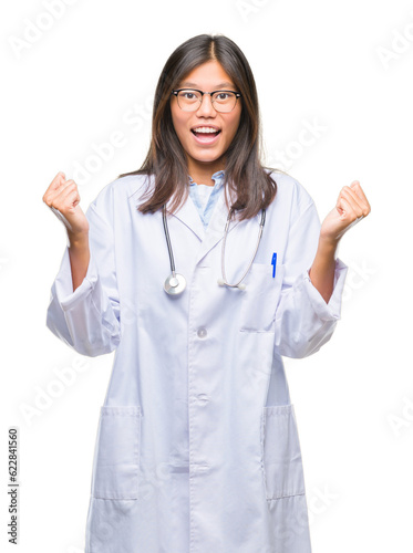 Young asian doctor woman over isolated background celebrating surprised and amazed for success with arms raised and open eyes. Winner concept.