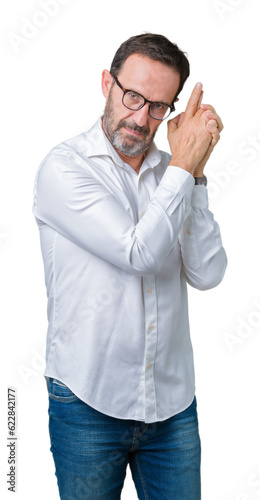 Handsome middle age elegant senior business man wearing glasses over isolated background Holding symbolic gun with hand gesture, playing killing shooting weapons, angry face