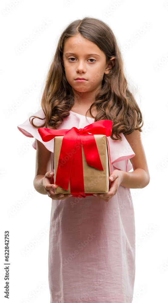 Brunette hispanic girl holding a gift with a confident expression on smart face thinking serious Brunette hispanic girl holding a gift with a confident expression on smart face thinking serious