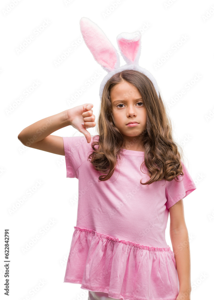 Brunette hispanic girl wearing easter rabbit ears with angry face, negative sign showing dislike with thumbs down, rejection concept Brunette hispanic girl wearing easter rabbit ears with angry face, negative sign showing dislike with thumbs down, rejection concept