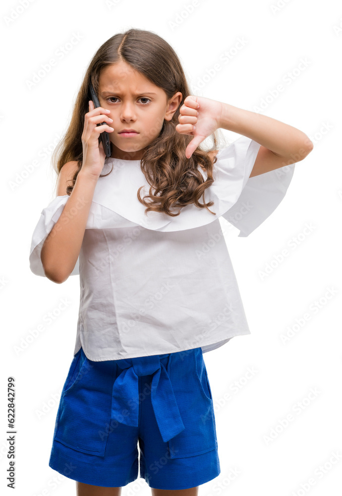 Brunette hispanic girl using smartphone with angry face, negative sign showing dislike with thumbs down, rejection concept Brunette hispanic girl using smartphone with angry face, negative sign showing dislike with thumbs down, rejection concept