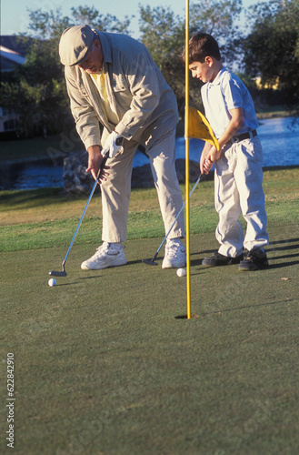 Grandfather playing golf with his grandson, Miami, Florida, USA