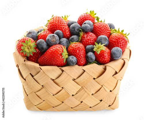 Wicker basket with ripe strawberry and blueberry on white background