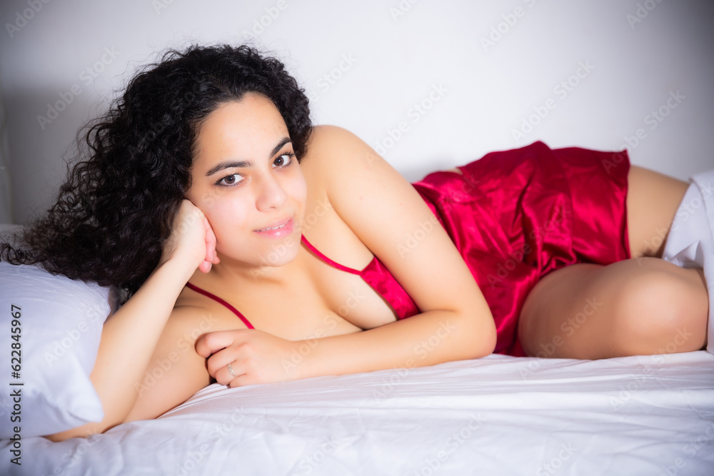 Naklejka premium Portrait of seductive girl in red lingerie on the bed