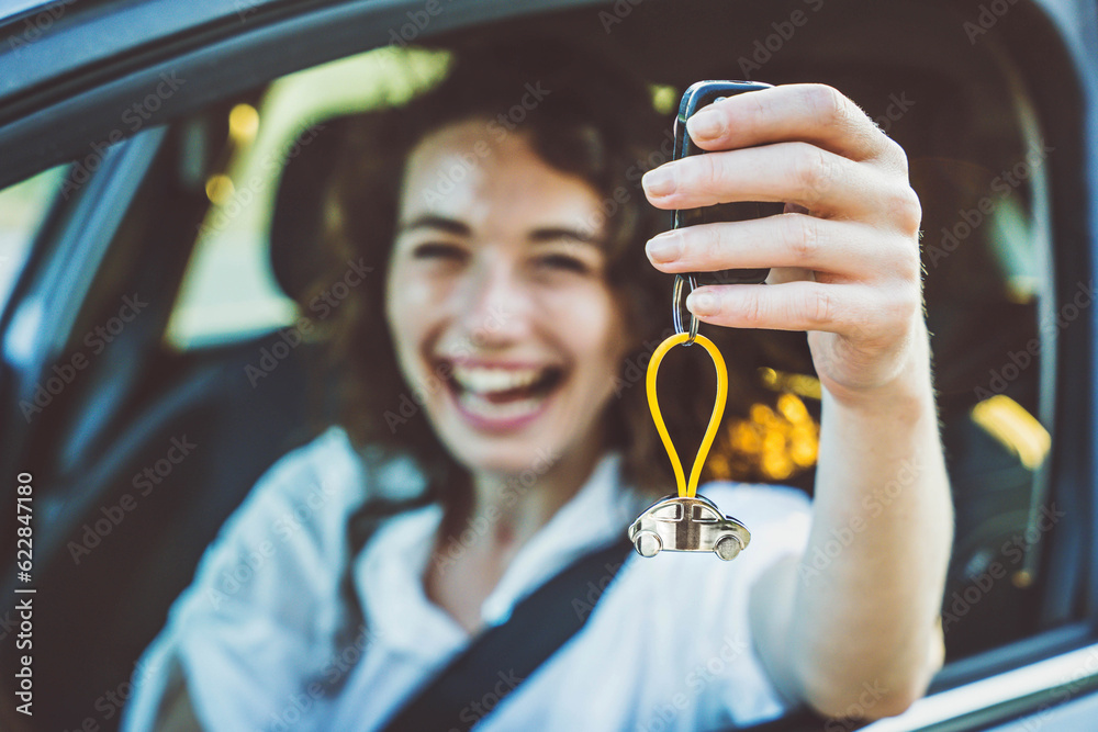 Happy woman buying new car Delightful girl showing auto keys to the camera Automobile