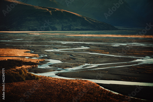 Winding river through alpine valley landscape at sunset
