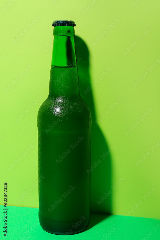 Bottle of cold beer on green background Bottle of cold beer on green background