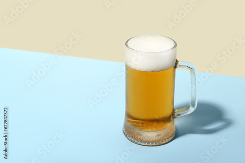 Mug of cold beer on color b...
