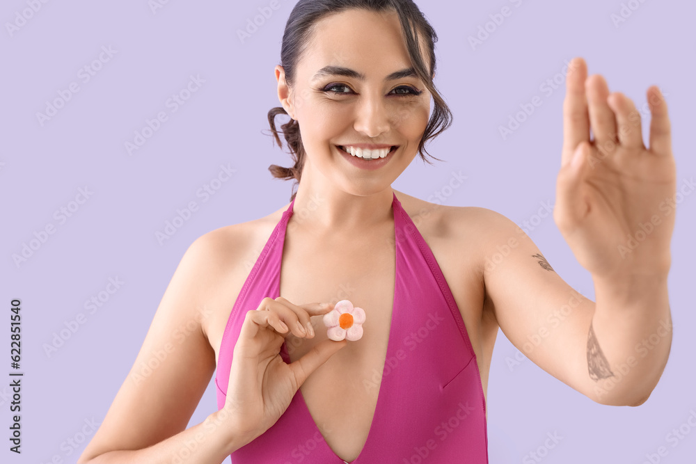 Young woman in swimsuit with candy on lilac background, closeup Young woman in swimsuit with candy on lilac background, closeup