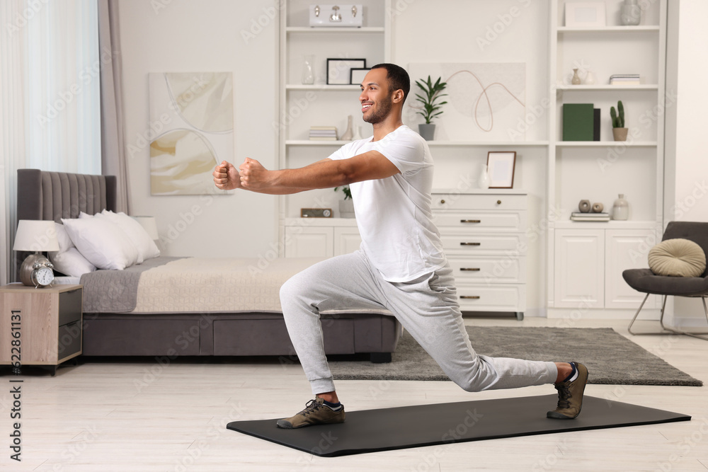Man doing morning exercise on fitness mat at home Man doing morning exercise on fitness mat at home