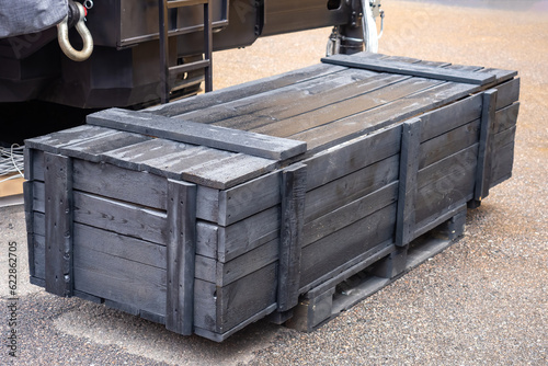 Wooden box is on ground. Co...