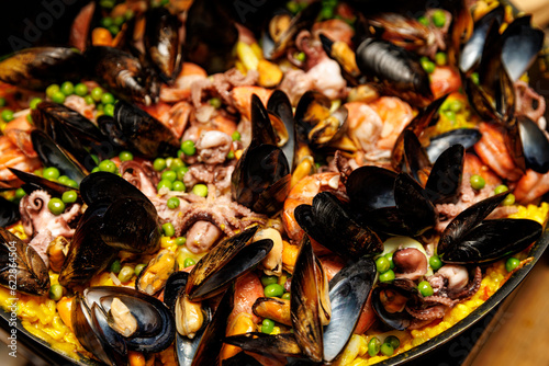 Spanish seafood paella with mussels and shrimps close-up view.