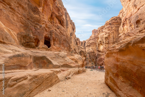 Visitors pass through the canyon ravine on the way to the Treasury building in the ancient Nabataean Rose City of Petra, Jordan.