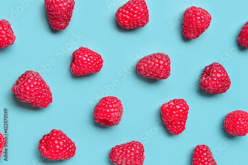 Many fresh raspberries on blue background