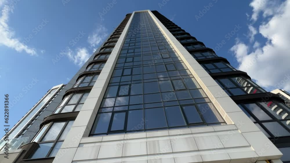 Newly built modern high-rise residential skyscrapers exterior with stylobate. Bottom up view. Extreme wide angle shot Newly built modern high-rise residential skyscrapers exterior with stylobate. Bottom up view. Extreme wide angle shot
