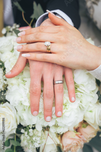 Close Up of Bride and Groom Holding Hands with Wedding Rings and White Flowers – Muslim Wedding, Marriage Ceremony, Love, Romance, Commitment, Engagement, Bridal Jewelry, Islamic Culture, Marriage
