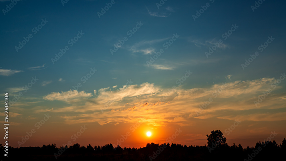 Obraz premium Green field and beautiful summer sunrise. Beautiful clouds on the sky.