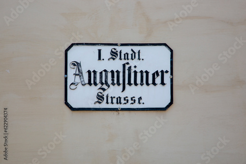 A sign with the name of the Augustinerstrasse street in Gothic script in the center of Vienna