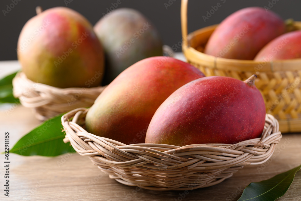 Mango fruit (Palmer mango) in basket on wooden background, Tropical fruit Mango fruit (Palmer mango) in basket on wooden background, Tropical fruit