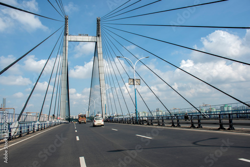 Fototapeta Naklejka Na Ścianę i Meble -  9th July, 2023, Kolkata, West Bengal, India: POV of a bike rider of morning traffic movement on Bidyasagar Setu or Second Hoogly bridge at Kolkata.