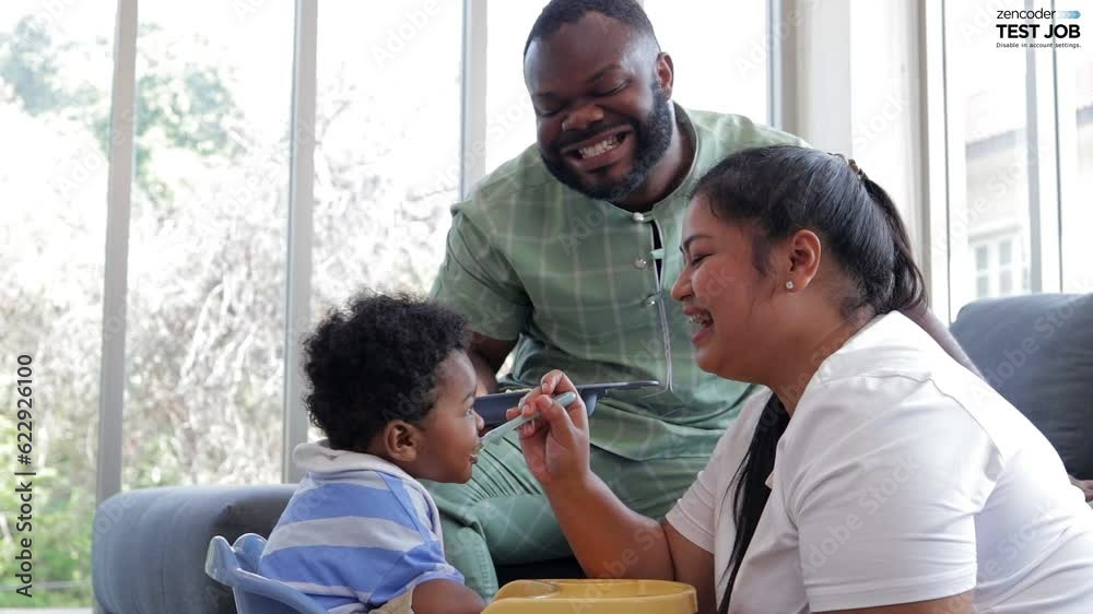 The boy smiled happily with his mother and father as they ate in the living room at home. Development of preschool children. food menu for 1 year old baby The boy smiled happily with his mother and father as they ate in the living room at home. Development of preschool children. food menu for 1 year old baby