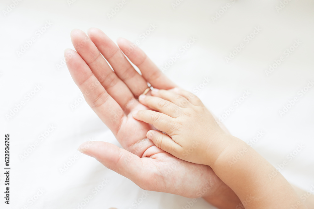 重なる赤ちゃんと母の手 重なる赤ちゃんと母の手