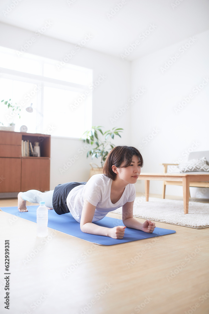 室内の床でトレーニングする女性 室内の床でトレーニングする女性