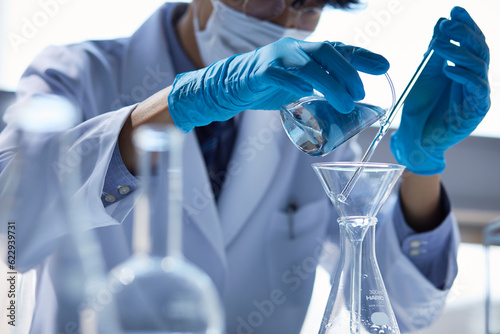 白い空間で実験をしている白衣を着た男性