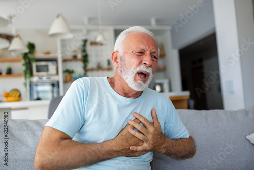 Wallpaper Mural Senior man presses hand to chest has heart attack suffers from unbearable pain, Mature man with pain on heart in living room. Senior man suffering from bad pain in his chest heart attack at home Torontodigital.ca