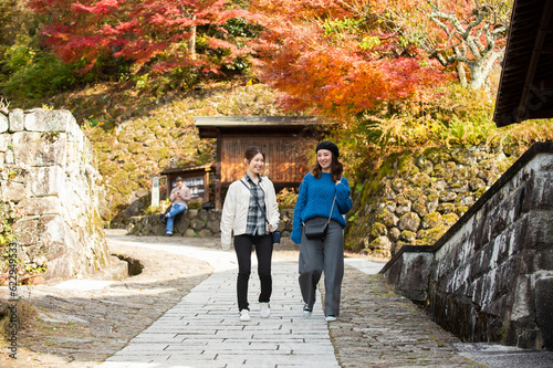 紅葉を見ながら観光地を散策する女性２人